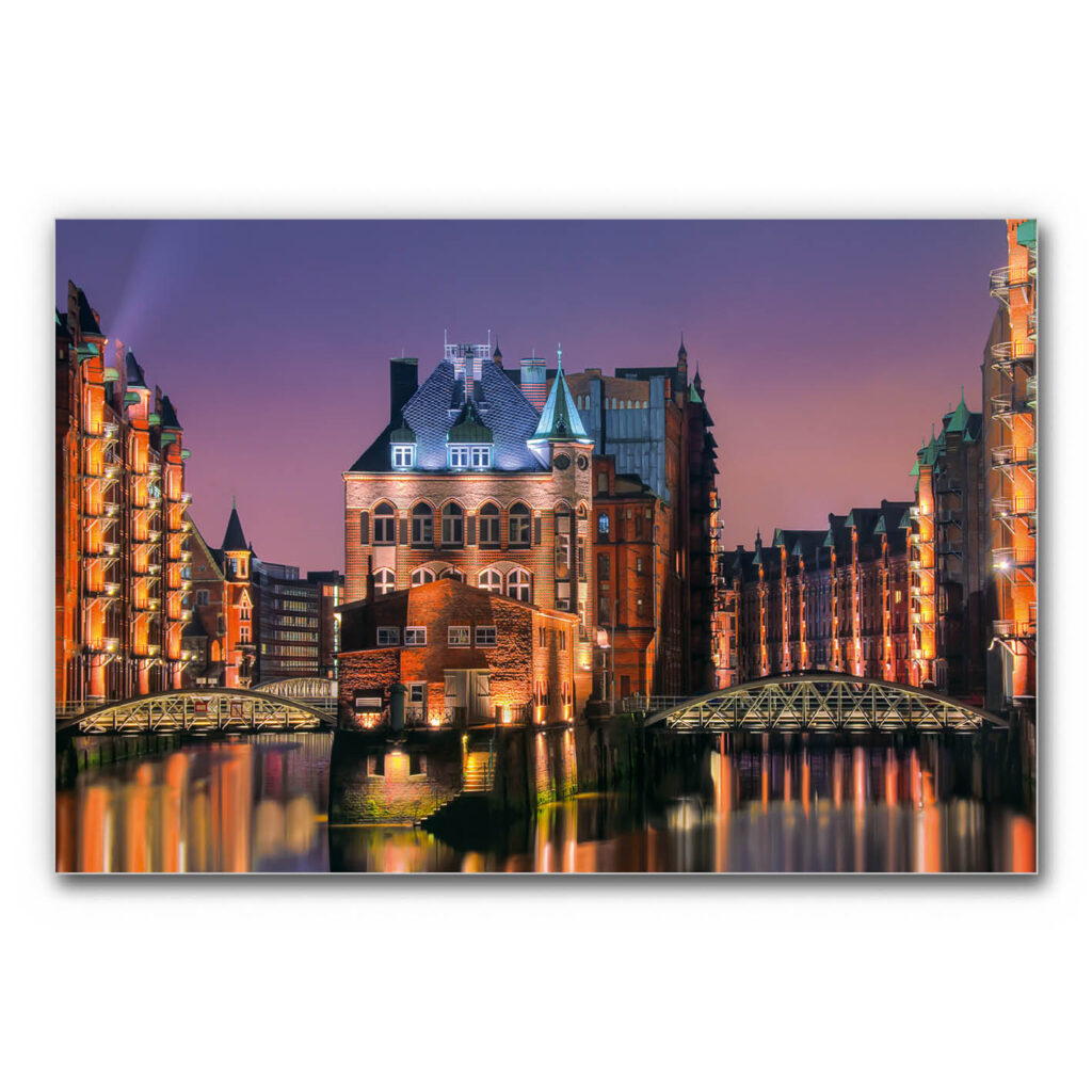 Schallabsorberbild Hamburg Speicherstadt mit beleuchtetem Wasserschloss bei Dämmerung, historische Backsteinarchitektur mit Brücken und Spiegelungen im Wasser.