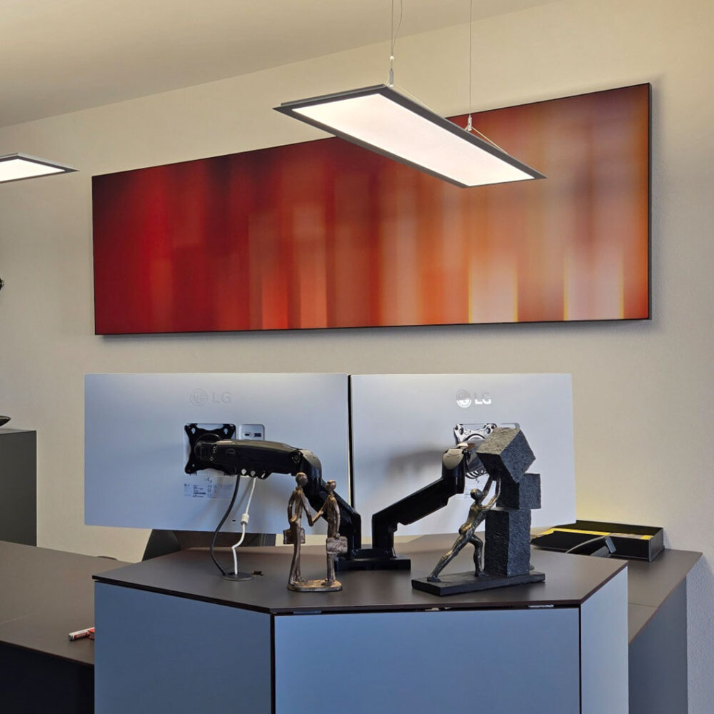 Schallabsorberbild hinter einem Schreibtisch mit 2 Monitoren