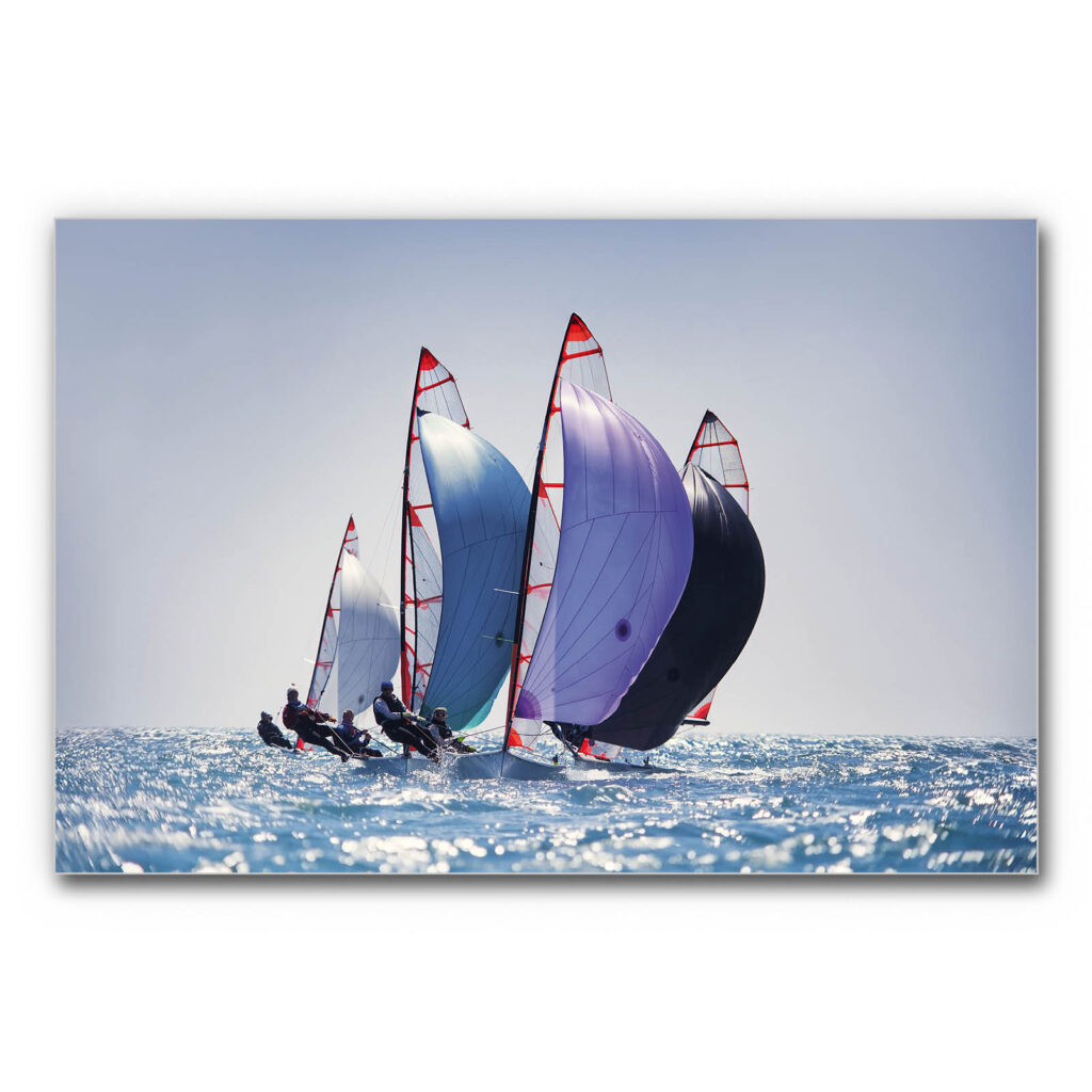 Schallabsorberbild Segelregatta mit mehreren Segelbooten, geblähten Spinnakersegeln in Blau- und Violetttönen auf bewegtem Meer bei klarem Himmel