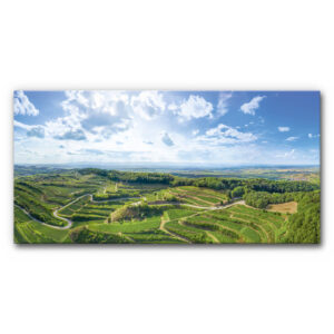 Akustikbild Panorama Weinlandschaft Natur mit weitem Blick über grüne Weinberge und Hügel des Kaiserstuhls unter blauem Himmel mit Wolken im XL-Panoramaformat.