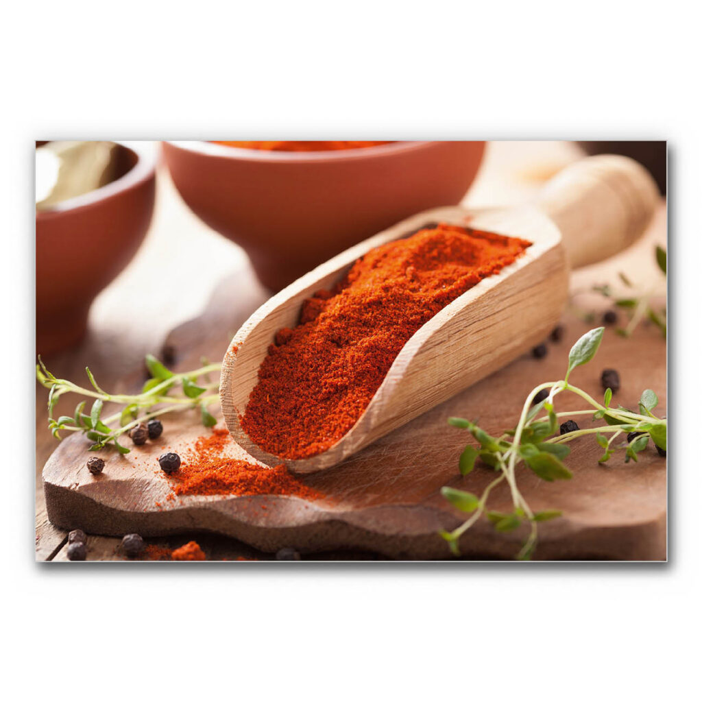 Akustikbild Paprika - Eine Nahaufnahme einer Küchen-Holzschaufel gefüllt mit Paprikapulver