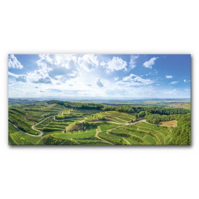 Akustikbild Panorama Weinlandschaft Natur mit weitem Blick über grüne Weinberge und Hügel des Kaiserstuhls unter blauem Himmel mit Wolken im XL-Panoramaformat.